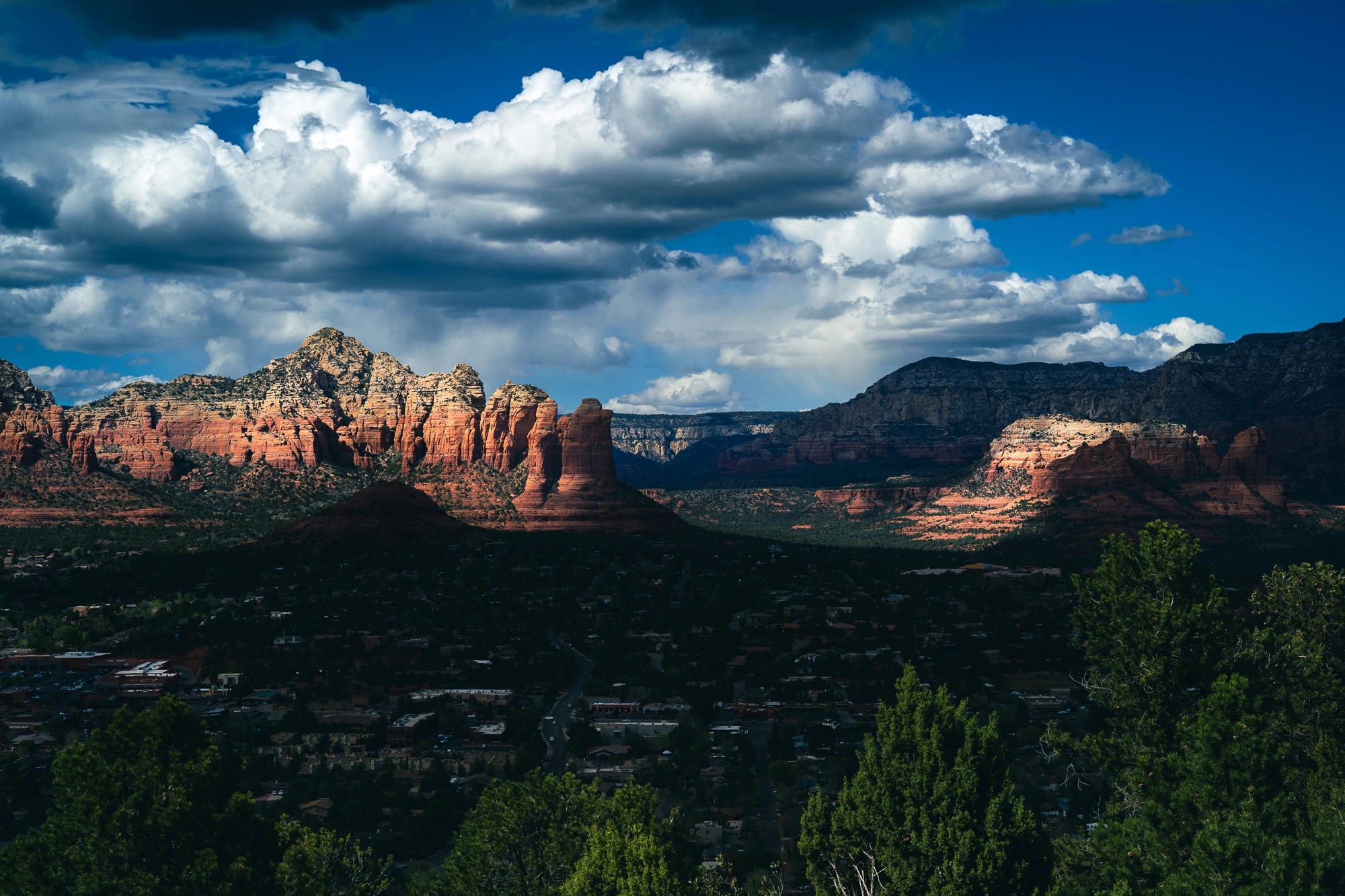Red rock formations rise against a clear sky in Sedona, Arizona